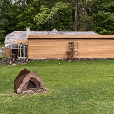 Southwood Holography Laboratories studio in mid-hudson, New York | Image shows a building set in the woods with a lawn and scultpure in the forground